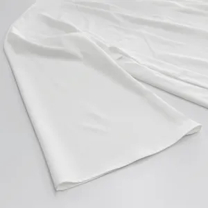 Dettaglio di abbigliamento bianco tinta unita, con tessuto liscio e cuciture pulite.