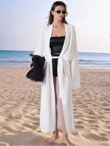 Dettaglio cardigan lungo bianco da spiaggia estivo, stile abito legato tinta unita.