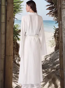 Vista dettagliata del set di cardigan lungo bianco indossato sullo sfondo della spiaggia.