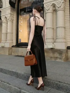 Élégante robe nuisette noire en satin avec de fines bretelles pour un style estival chic.