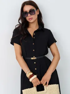 Detailansicht des eleganten schwarzen Hemdkleids mit goldenem Gürtel und Armbändern.
