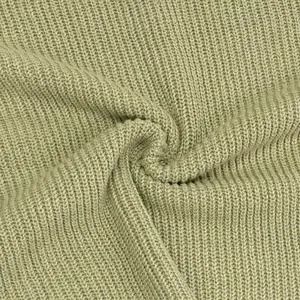 Knitted sweater fabric detail, soft ribbed texture, close-up view showing knit quality.