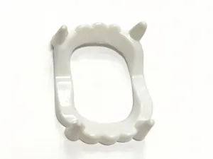 White vampire fangs prop detail view, creative Halloween costume accessory decoration.