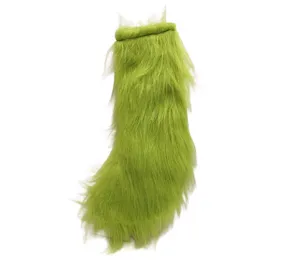 Gros plan de chaussette de Noël en peluche verte, ornement suspendu en fausse fourrure.