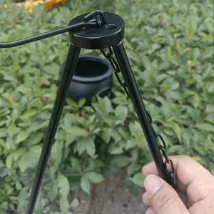 Close-up of black metal tripod stand and hanging chain for outdoor camping cauldron decoration.