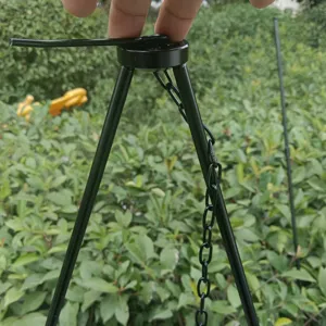 Outdoor camping tripod detail, black metal campfire cooking pot hanging chain bracket for hiking.