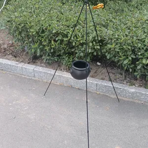Halloween portable black iron tripod camping pot rack for outdoor campfire cooking and decor.
