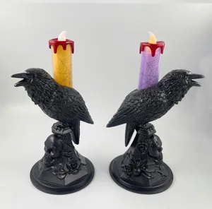 Close-up detail of Halloween crow candle holders with LED lights, skull and spiderweb gothic decor.
