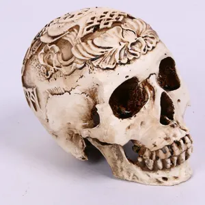 Resin carved skull figurine detail showing intricate retro floral patterns and antique finish.
