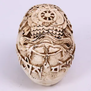 Resin carved skull figurine with detailed esoteric Tibetan motifs for Halloween party decoration.