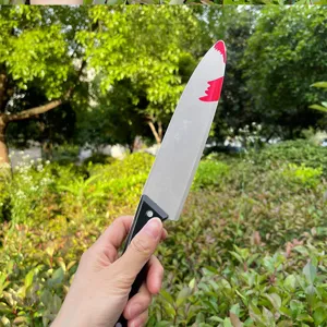 Close-up detail of Halloween plastic bloody dagger prop, realistic fake blood effect toy knife.