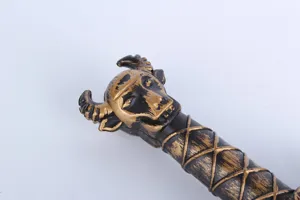 Detail shot of toy sword handle with bull head design in black and gold plastic for cosplay.