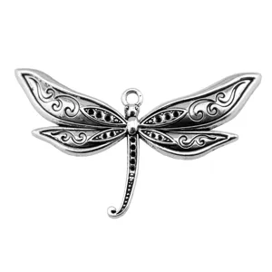 Detailed close-up of a large silver dragonfly pendant, featuring intricate wing scrollwork patterns.