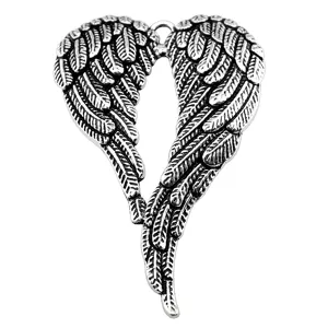 Detailed shot of vintage silver angel wings pendant jewelry finding, exquisite carved texture.