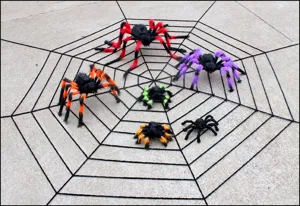 Halloween plush spider props scene detail display with large web and assorted colorful spiders.