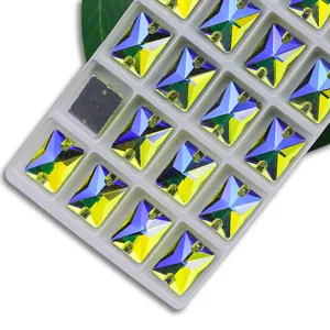 Gros plan de strass en verre AB rectangulaires dans un plateau blanc pour coudre et décorer.