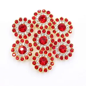 Primer plano detallado de pedrería de costura de girasol de 14mm con cristal rojo y base dorada.