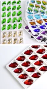 Primer plano detallado de cristales de estras de costura en gota multicolores en bandejas.