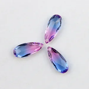 Gros plan de pendentifs en cristal en forme de goutte dégradée avec un trou pour bijoux DIY.