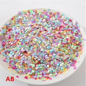 Primer plano de lentejuelas de corazón láser coloridas en plato blanco, accesorio de joyería DIY.