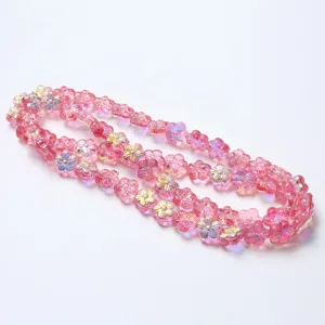 Detalle de cuentas de flores de vidrio rosa con revestimiento iridiscente para joyería.