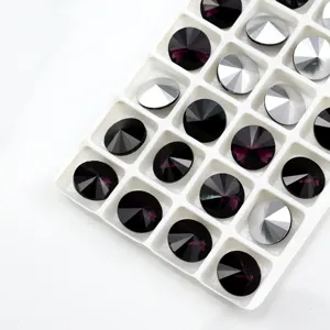 Close up of faceted round pointed back crystal glass rhinestones in a white tray grid.