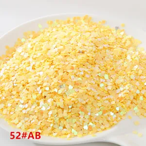 Detalle en primer plano de lentejuelas de corazón amarillo, ideales para accesorios de ropa.