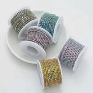 Close-up of colorful rhinestone cup chains on white plate, perfect for nail art and DIY craft decor.