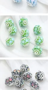Close-up of DIY floral bead charms, multi-color diamond-cut spheres with pearls for crafts.