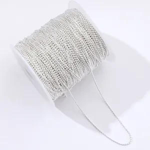 Close-up of a spool of shiny silver tiny bead chains for DIY nail art and craft decor.