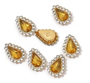 Close up of teardrop shaped rhinestone claw drill DIY accessories with yellow stones.