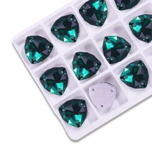 Detailed close-up of faceted green triangular flatback rhinestones in white tray.