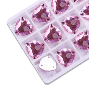 Detail shot of pink fat triangle glass sew-on rhinestones in a tray, DIY craft supplies.