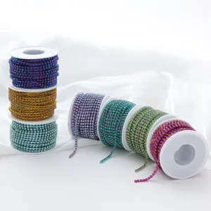 Close-up detail of colorful gradient AB glass rhinestone claw chains on white spools.