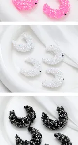 Detailed view of sparkly crescent rhinestone charms, perfect for DIY bag chains and crafts.