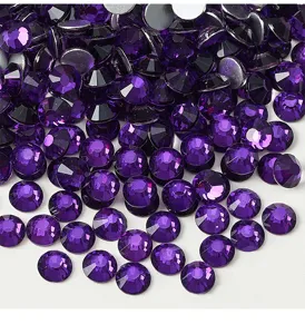 Purple glass rhinestones close up, sparkly faceted crystal flatbacks for DIY garments crafts.