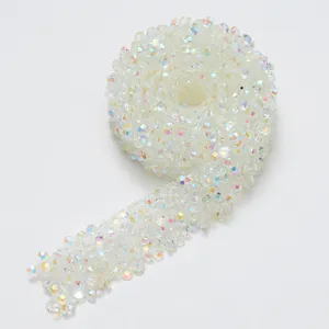 Detailed view of adhesive crystal rhinestone ribbon roll, sparkling AB color DIY trim.
