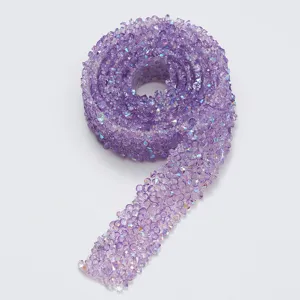 Close-up detail of purple resin rhinestone trim ribbon, showing sparkling crystal texture.