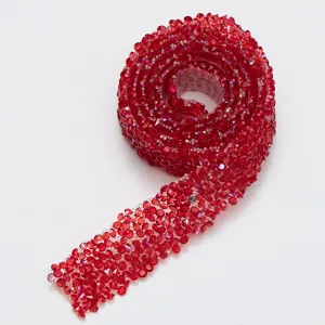 Close-up detail of red rhinestone ribbon trim, self-adhesive sparkling crystal mesh roll.