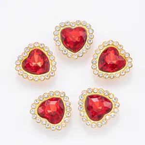 Gros plan de boutons en strass en forme de cœur avec cristal rouge et bordure blanche.