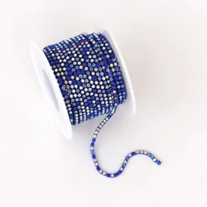Primer plano de cadena de pedrería azul en carrete, ideal para manualidades y detalles de ropa.