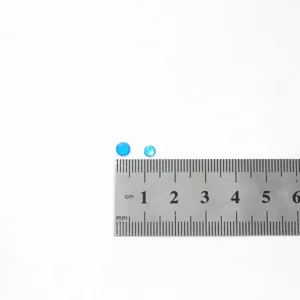 Close-up of blue flatback crystal rhinestones, tiny round nail art diamonds for DIY crafts.