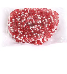 Close-up detail of red resin rhinestone and white pearl DIY decorative adhesive ribbon.