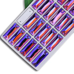 Closeup of rectangular dual-hole AB crystal rhinestones in purple orange iridescence, sewing diy.