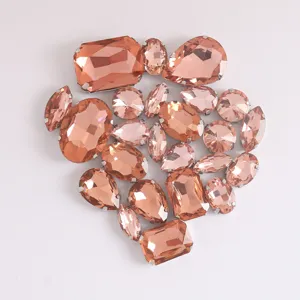 Vista detallada de pedrería de cristal en melocotón surtida con garras para manualidades DIY.