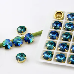 Nahaufnahme von glänzenden 12mm blauen Farbverlauf Strasssteinen mit Goldkrallen für Handwerk.
