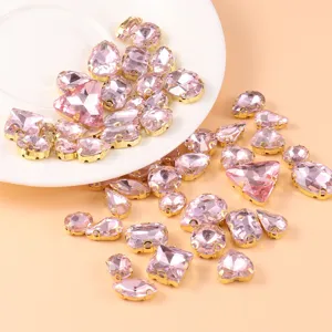 Detailed close-up of pink crystal glass rhinestones with gold claw settings for DIY crafts.