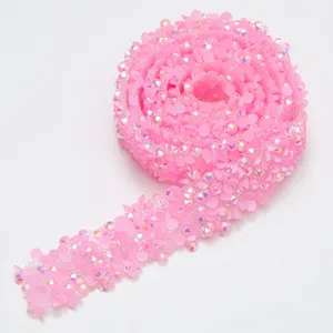 Pink resin rhinestone trim detail, sparkling crystal ribbon for DIY crafts and clothing decoration.