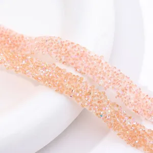 Detailed close-up of sparkling peach resin rhinestone banding trim for DIY craft accessories.