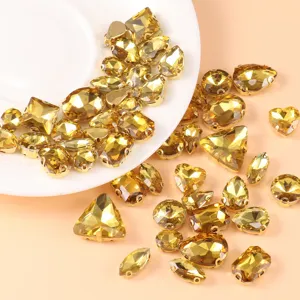 Detail view of mixed gold crystal glass rhinestones with metal claw settings for DIY sewing crafts.